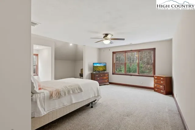 a bedroom with a bed and a large window