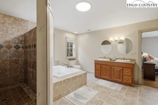 a spacious bathroom with a tub sink and mirror