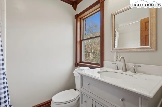 a bathroom with a granite countertop sink mirror vanity and toilet