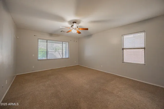 a view of a big room with chandelier fan and windows