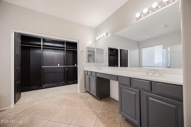 a large bathroom with a granite countertop sink a large mirror and a bathtub