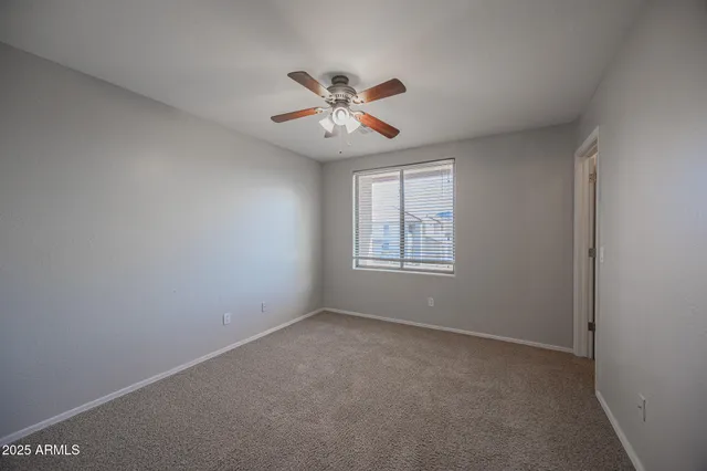 a view of an empty room with a chandelier fan