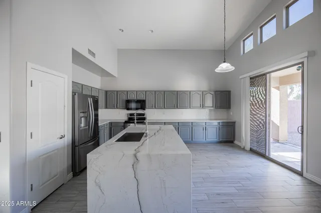 a kitchen with a sink and steel appliances