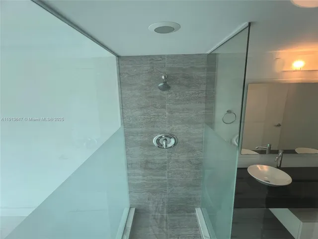 a bathroom with a granite countertop shower and a sink