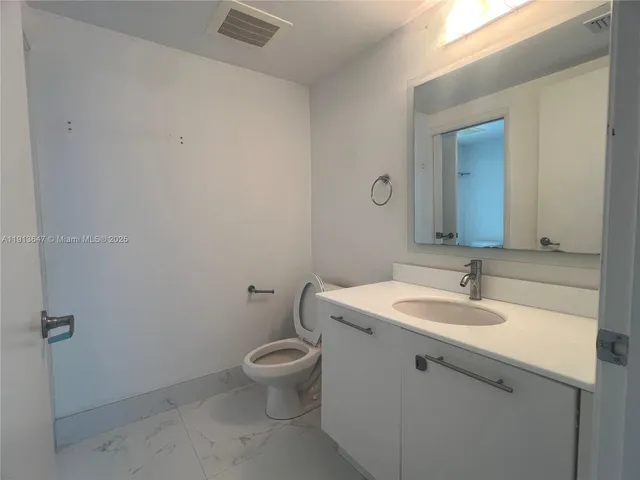 a bathroom with a sink and mirror with toilet