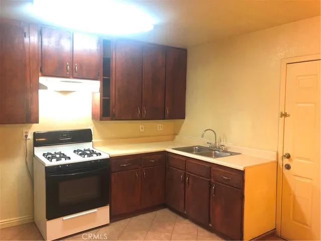 a kitchen with a sink a stove and cabinets