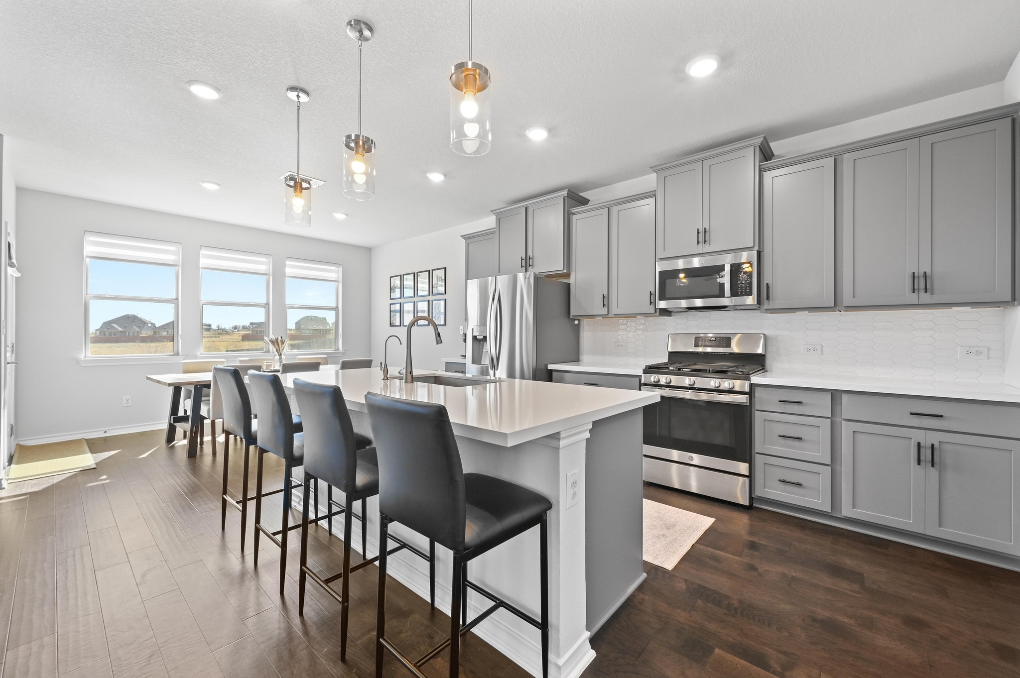 116 Small Seed Drive Buda, TX 78610 - Photo 10 of 40 Kitchen with stainless steel appliances, gray cabinets, pendant lighting, tasteful backsplash, and a center island with sink