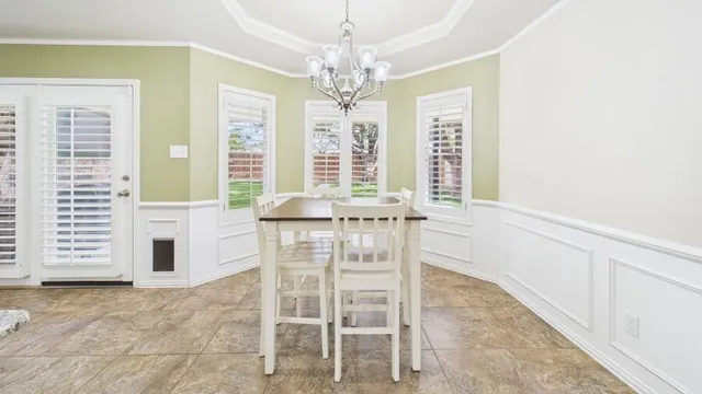 a view of a dining room with furniture and chandelier