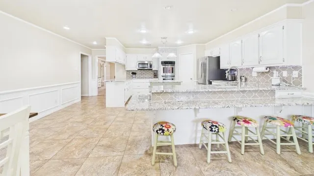 a large kitchen with a table and chairs