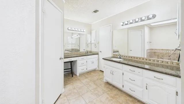 a spacious bathroom with a granite countertop sink mirror and