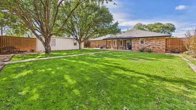 a backyard of a house with table and chairs