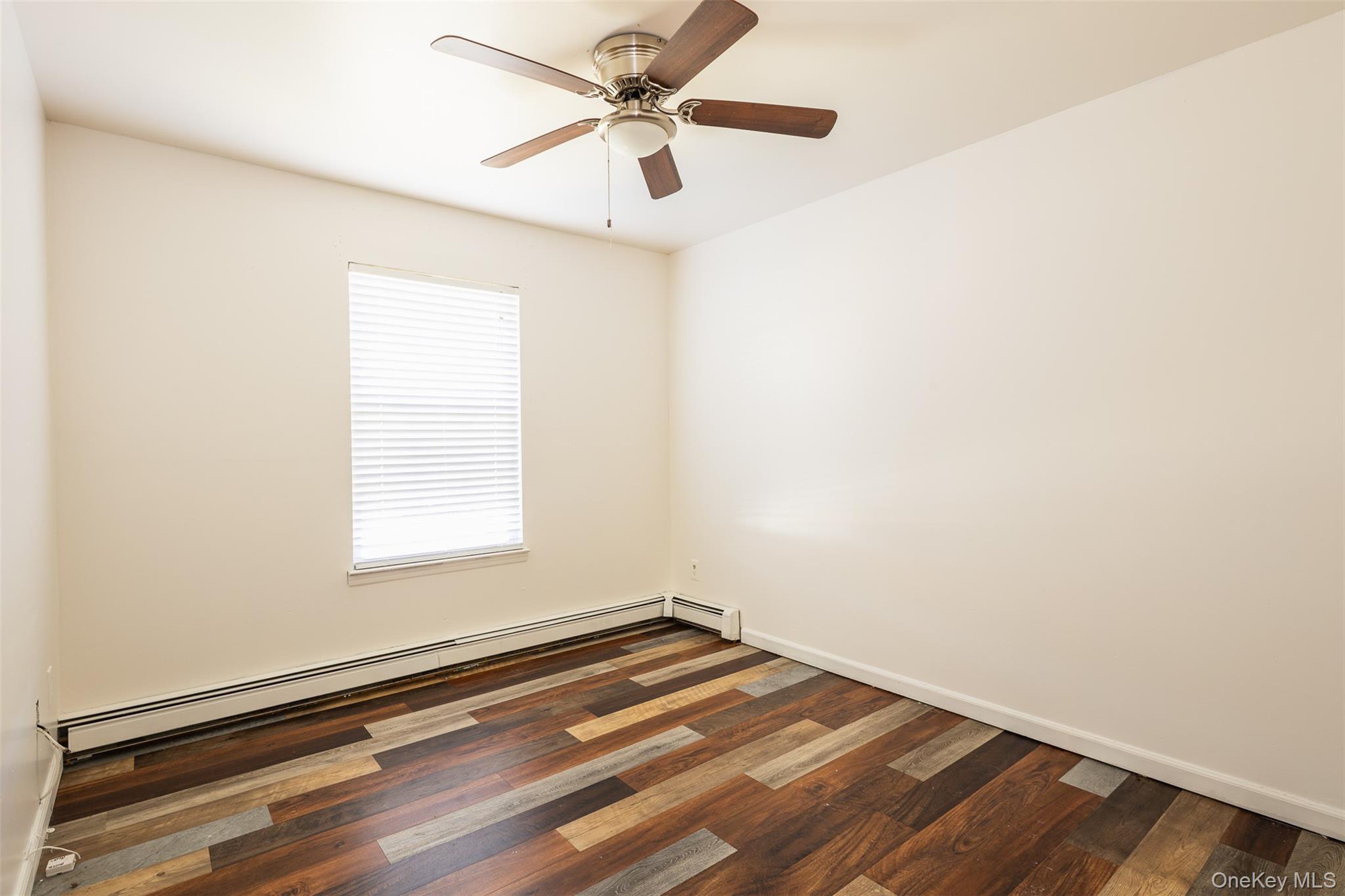 182 Whittier Drive Mastic Beach, NY 11951 - Photo 13 of 25 an empty room with a window and a ceiling fan
