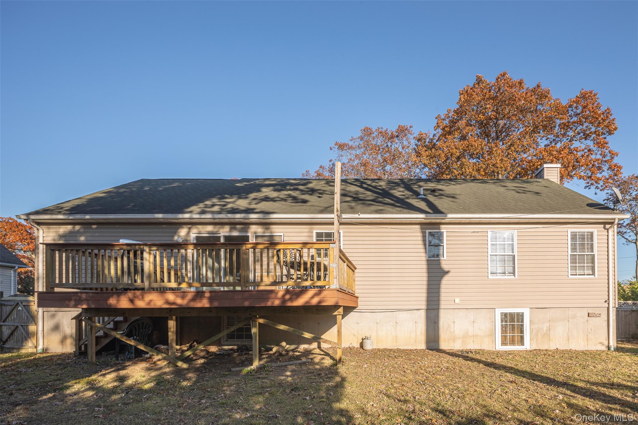 182 Whittier Drive Mastic Beach, NY 11951 - Photo 22 of 25 a view of a patio with table and chairs with wooden floor and fence