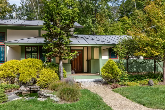 a front view of a house with a garden