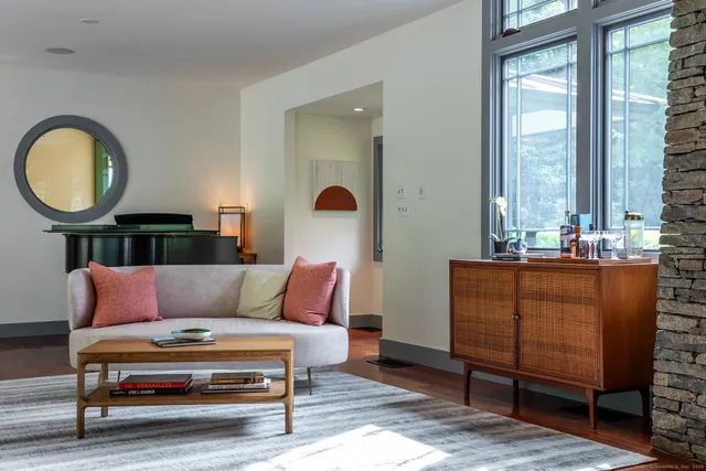 a living room with furniture a window and a potted plant