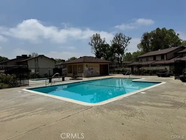 a view of a swimming pool with a patio and a yard