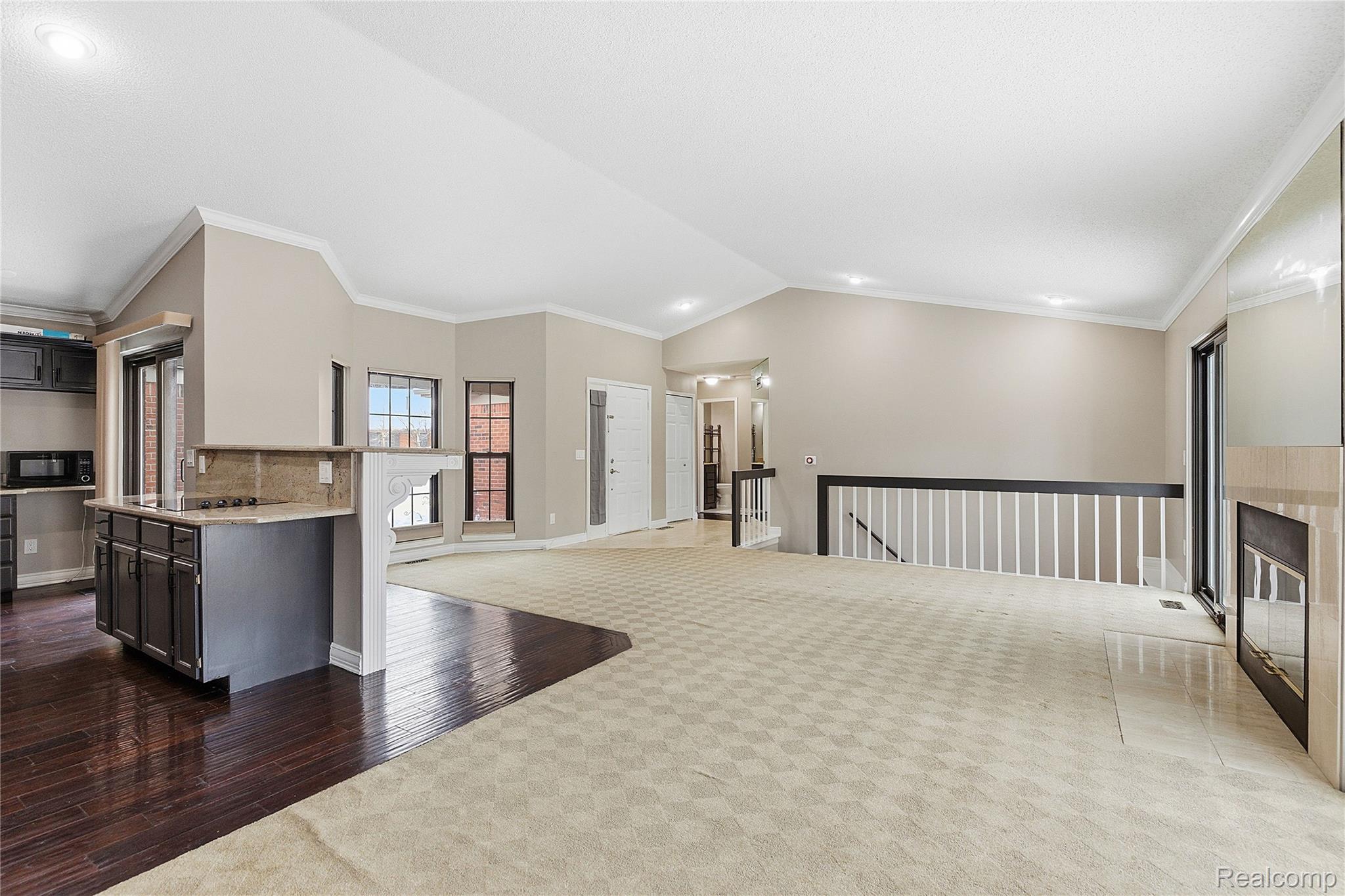 7154 Westchester Road West Bloomfield, MI 48322 - Photo 38 of 38 Kitchen featuring dark carpet, crown molding, open floor plan, light stone counters, and dark wood-style floors