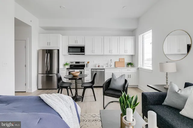 a living room with furniture a refrigerator and a dining table