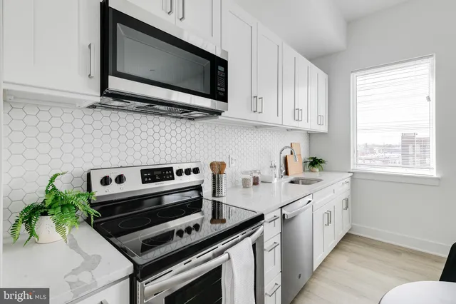 a kitchen with stainless steel appliances a stove a microwave a sink and cabinets