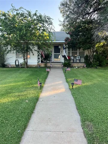 a front view of a house with a yard and fountain