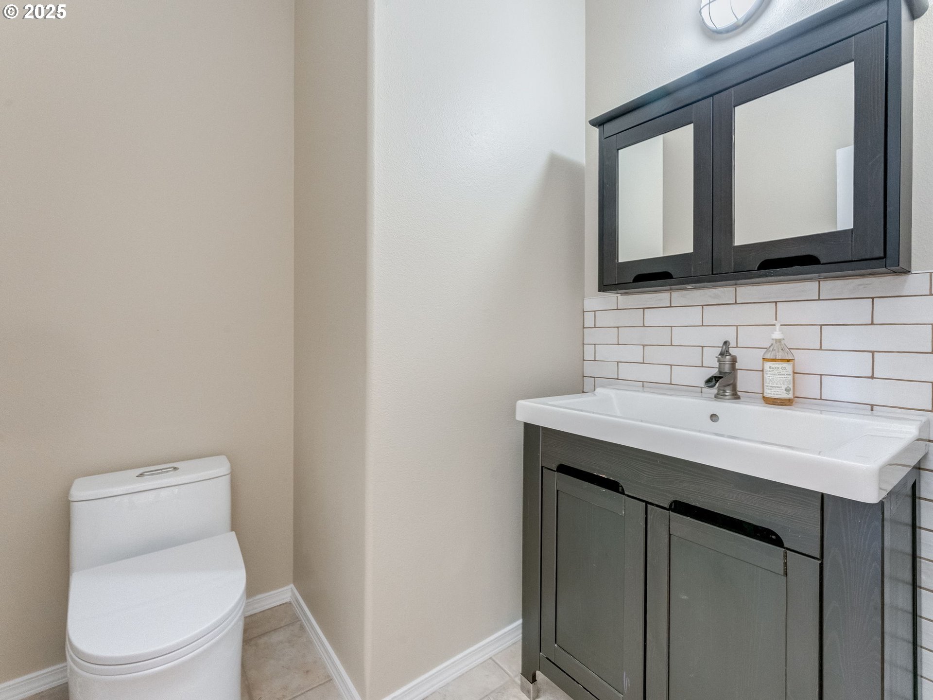 5641 Southeast Chase Loop Gresham, OR 97080 - Photo 3 of 39 a bathroom with a toilet a sink a mirror and vanity