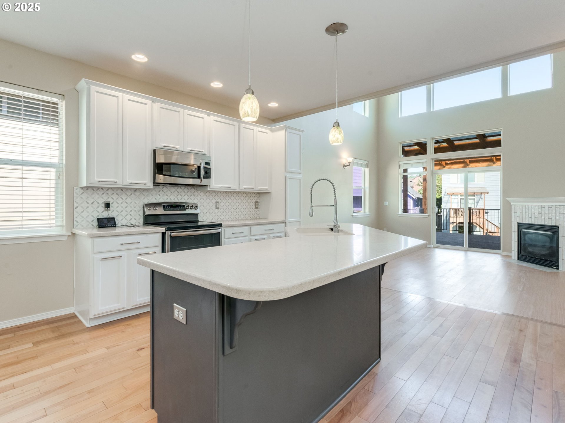 5641 Southeast Chase Loop Gresham, OR 97080 - Photo 4 of 39 a kitchen with kitchen island a sink and a stove top oven with wooden floor