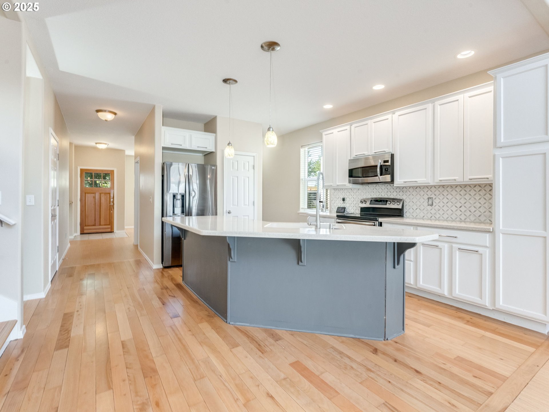 5641 Southeast Chase Loop Gresham, OR 97080 - Photo 5 of 39 a large kitchen with kitchen island a sink a stove a refrigerator and white cabinets