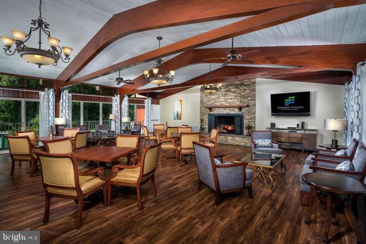 6001 Hunt Ridge Road, Unit 3622 Baltimore, MD 21210 - Photo 5 of 20 a living room with furniture a fireplace and a dining table