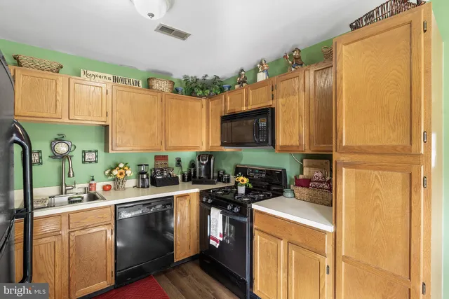 a kitchen with a sink stove top oven and cabinets