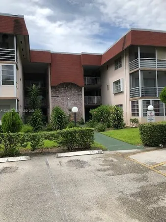 a front view of a house with a yard and potted plants