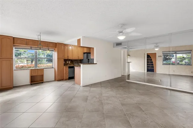 a view of kitchen with stainless steel appliances kitchen island granite countertop a refrigerator and a stove top oven