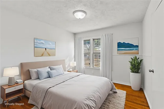 a bedroom with a large bed and a potted plant