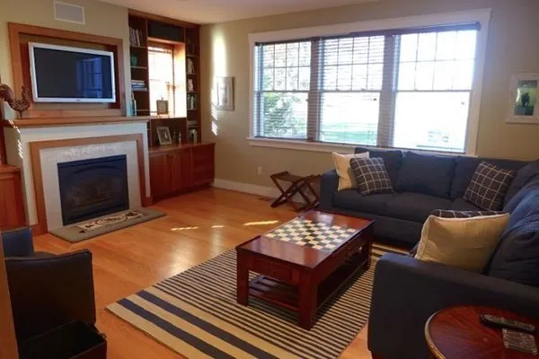 a living room with furniture a fireplace and window