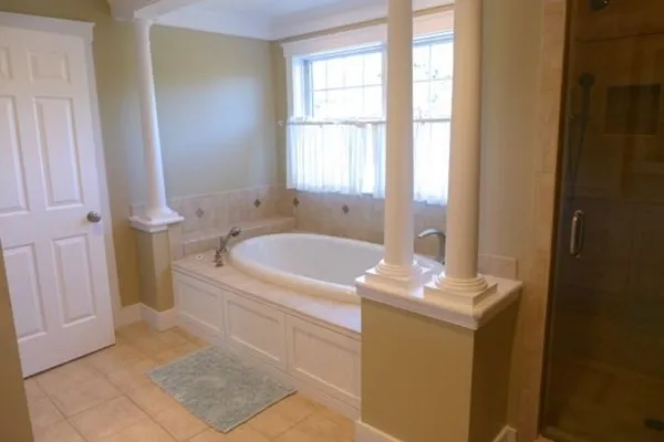 a bathroom with a tub sink and mirror