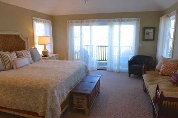 a spacious bedroom with a bed and a couch next to a window