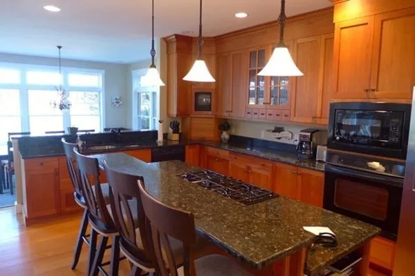a kitchen with stainless steel appliances granite countertop a sink a stove a table and chairs