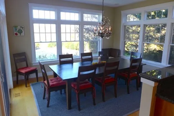 a view of a dining room with furniture a chandelier and wooden floor