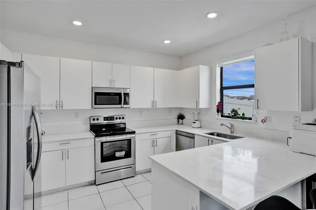 a kitchen with white cabinets and stainless steel appliances