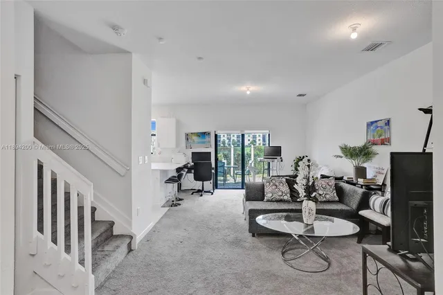 a living room with furniture a flat screen tv and a table