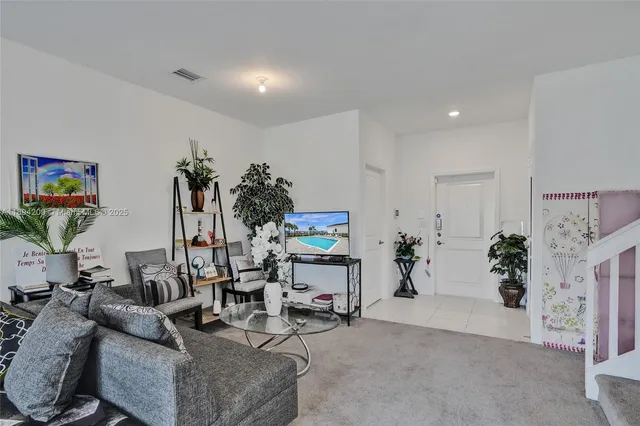 a living room with furniture and flowers