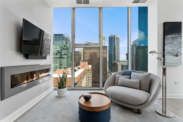 a living room with furniture a flat screen tv and a fireplace