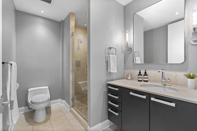 a bathroom with a granite countertop sink toilet and shower