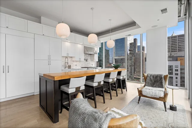 a dining hall with stainless steel appliances kitchen island granite countertop a table and chairs