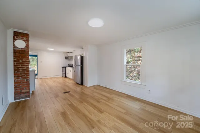 a view of a room with wooden floor and window