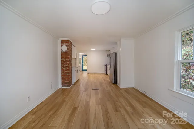 a view of empty room with wooden floor