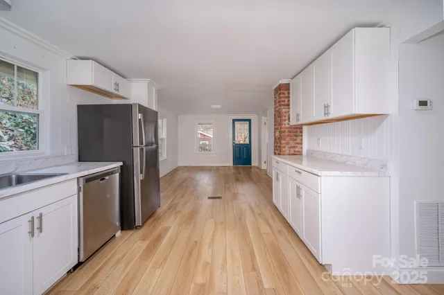 an empty room with wooden floor and cabinet