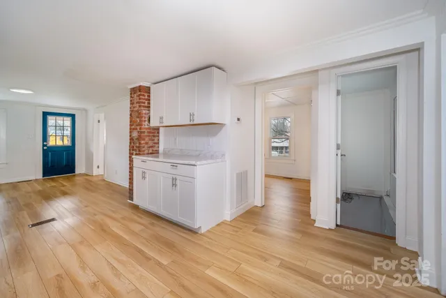 a view of empty room with wooden floor and closet