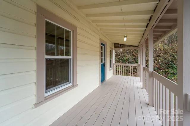 a view of a porch with wooden floor and floor to ceiling window