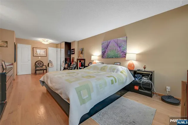 a bed sitting in a spacious bedroom next to a window