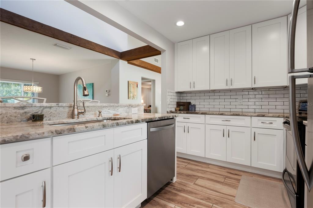 3804 Sun Eagle Lane Bradenton, FL 34210 - Photo 15 of 55 a kitchen with granite countertop white cabinets sink and stainless steel appliances